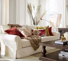 a living room filled with lots of furniture and pillows on top of a coffee table