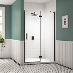 a white and black tiled bathroom with a walk in shower next to a potted plant