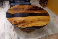 a wooden table sitting on top of a white floor next to a black leather chair