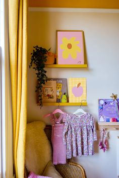 a baby's room with clothes and toys on the wall