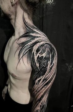 a man's arm with black and grey ink on it, which has an intricate design