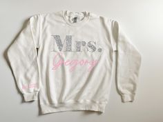 a white sweatshirt with the words mrs grooy printed in pink and silver on it