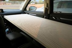 the interior of a vehicle with a long wooden table in the passenger side window,