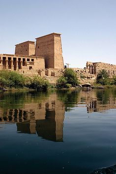 an ancient building is reflected in the water