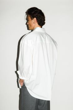 An ultra-crisp button up shirt with the effortless proportions of 90's Wall Street. Worn untucked or half-tucked, this oversized, billowy office staple makes for the ultimate off-duty move. Constructed from 100% pima cotton, a superior high-grade cotton known for it's incredible softness. Oversized Button Down, Outfits With White Button Up Shirt, White Oxford Shirt Outfit, White Oversized Shirt Outfit, White Shirt Outfit For Men, Oxford Shirt Outfit, Male Photoshoot, Oversized Shirt Outfit, Male Reference