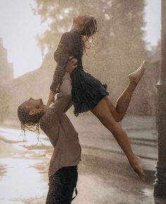 two people are playing in the rain with their feet up on each other's shoulders