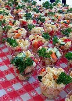 there are many small cups with food in them on the checkered tablecloths