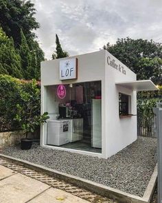 a small white building sitting on the side of a road