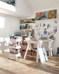 an artist's studio with easels and paintings on the wall