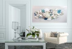 a living room filled with furniture and flowers on top of a glass table in front of a white wall