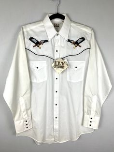 "Vintage Ely Cattlemen Eagle Western Shirt Size Medium  New Old Stock Features embroidered eagle, black snap buttons and black piping. Great condition  Has a dark spot on the shoulders from storage that will very likely wash out. 23\" across the chest  18.5\" shoulder to shoulder seam  24.5\" shoulder seam to cuff  33\" from collar fold to hem" Eagle Black, Fitted Blazer, Puffy Sleeves, Western Shirt, Vintage Western, Ely, Western Shirts, Button Shirt, Snap Button