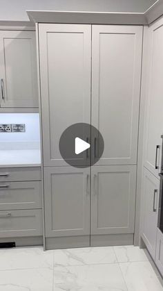 a kitchen with gray cabinets and white marble counter tops is featured in the video,