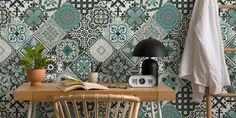 a wooden table with a lamp and a book on it next to a wallpaper