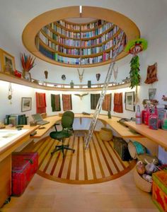 a room with bookshelves, desks and chairs in the middle of it