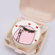 a pink cake with sunglasses on it in a foam container for someone's birthday