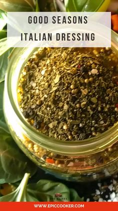 a glass jar filled with different types of spices and herbs on top of green leaves