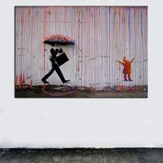 a person with an umbrella walking past a wall covered in rainbow streamers and graffiti