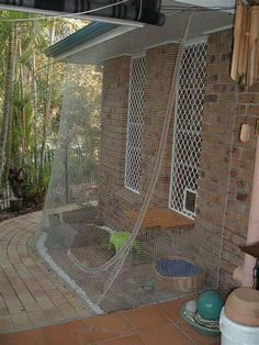 an outdoor area with a hammock and other items on the ground in front of a brick building