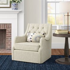 a living room with a chair, table and fire place in the corner on a blue rug