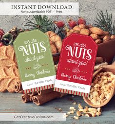 two christmas gift tags sitting on top of nuts next to other holiday treats and cookies