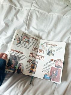 an open book with pictures on it sitting on top of a white bed spread in front of a person's hand