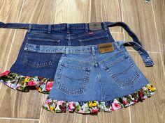 two pairs of jean shorts with floral ruffles on the bottom and one pair is blue