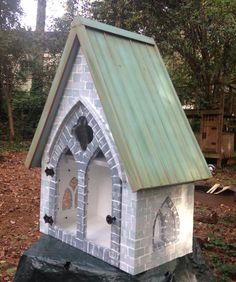 a bird house made out of bricks in the woods