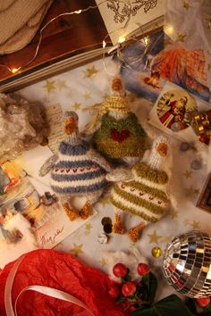 several knitted christmas ornaments and decorations on a bed with lights in the bedroom above them