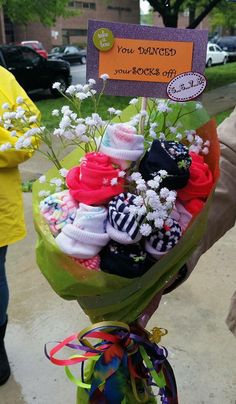 a bouquet of socks and baby's breath flowers is on display in front of a sign