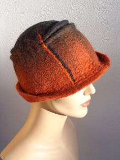 Assymetrical retro hat, brown and black felt cloche, 1920s inspired hat, art deco fashion, 20s accessory, winter hat. This woman felt cloche hat is made of 100% merino wool. It has been felted by hand. The shape is assymetrical and the colour combination is subtile, with black, brown and orange tones. It is a comfortable cloche, soft and light, inspired by the 20s fashion. A great retro accessory, easy to wear everyday! ** Turnaround time ** It will take 3-5 days to re-create a model similar to Brown Wool Cloche Felt Hat, Brown Wool Cloche Hat, Brown Cloche Felt Hat For Winter, Brown Cloche Hat For Fall, Fitted Retro Brown Cloche Hat, Fitted Brown Cloche Hat With Curved Brim, Cappello Cloche, Felted Hats, Retro Hat