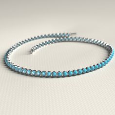 a blue beaded bracelet on a white surface