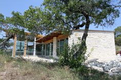 a small building sitting on top of a hill next to a tree