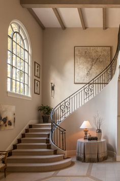 a staircase in a home with white walls and carpeted flooring next to a painting on the wall