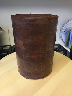 a large brown pot sitting on top of a wooden table next to an electric stove