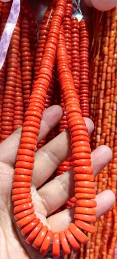 a person is holding some orange beads