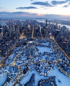 an aerial view of a large city with lots of trees and snow on the ground