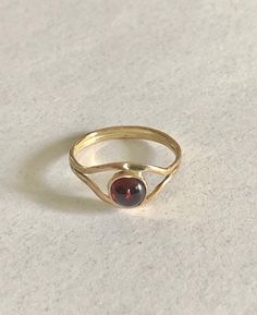 This 14 K gold ring features a 6 mm. garnet a very popular stone. The  splitter band gives to the ring a nice looking and is very comfortable. Yellow Gold Garnet Rings, Yellow Gold Garnet Rings With Round Cut, Garnet Rings With Polished Finish, Garnet Rings In Fine Jewelry Style, Classic Garnet Rings With Round Cut, Classic Garnet Round Cut Ring, Modern Garnet Rings For Formal Events, Modern Garnet Rings For Formal Occasions, Garnet Rings With Polished Finish - Fine Jewelry