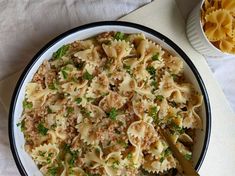 a white bowl filled with pasta and meat