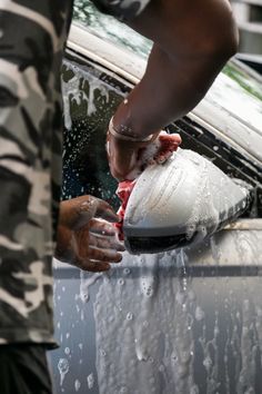 a man washing his car with soap and water