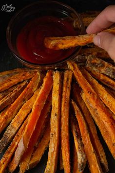 someone is dipping sauce on some sweet potato fries