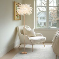 a bedroom with a bed, chair and floor lamp next to a large window in the corner