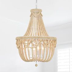 a chandelier hanging from the ceiling in a white room with wood beading