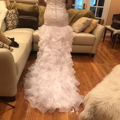 a woman in a wedding dress standing next to a couch