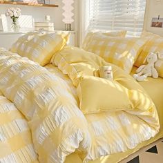 a bed with yellow comforters and pillows