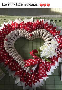 a red and white wreath on top of a cutting board