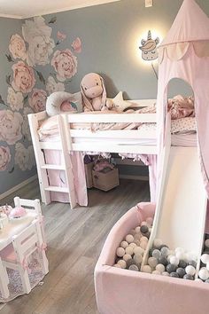 a child's bedroom with a pink bed and slide in the center, filled with balls