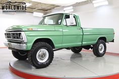 a green pick up truck parked in a garage