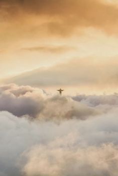 an airplane flying above the clouds at sunset