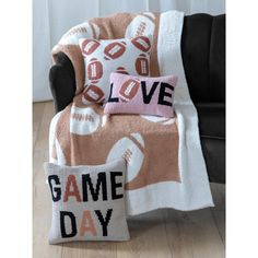 a blanket that says love game day on it next to a pillow with a football design