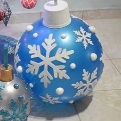 blue and white ornaments on the ground with snowflakes hanging from it's top